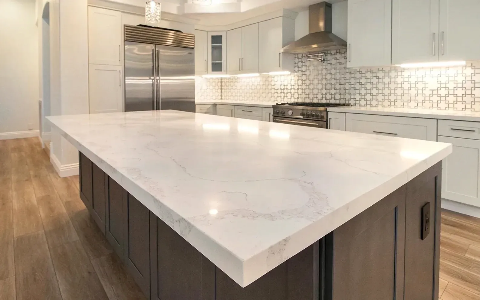 A kitchen island topped with veined marble