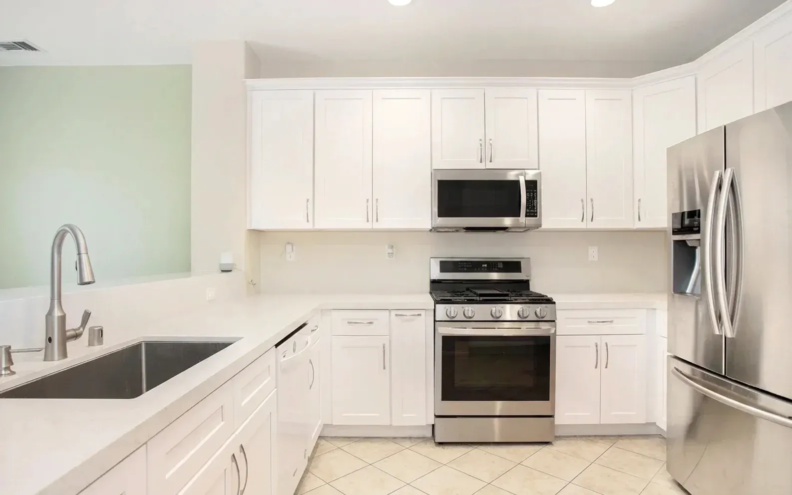 A white kitchen with stainless steel appliances